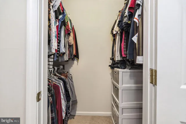 a view of walk in closet with clothes