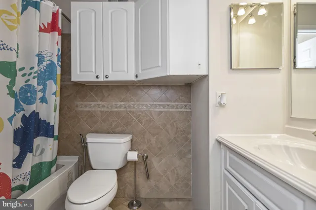 a bathroom with a granite countertop toilet sink and mirror