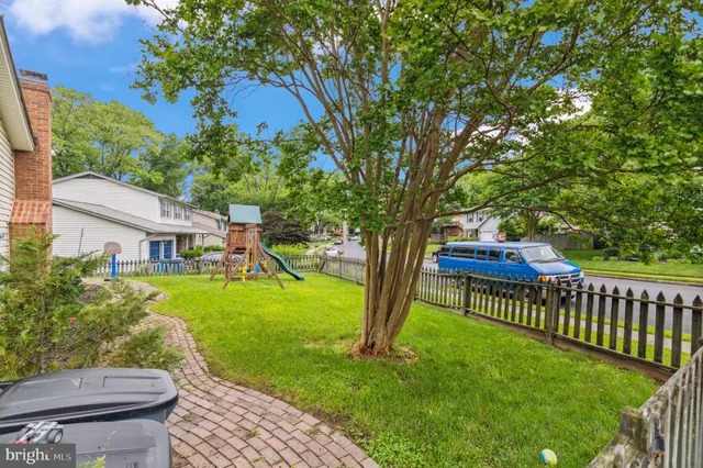 a view of a house with backyard and a tree