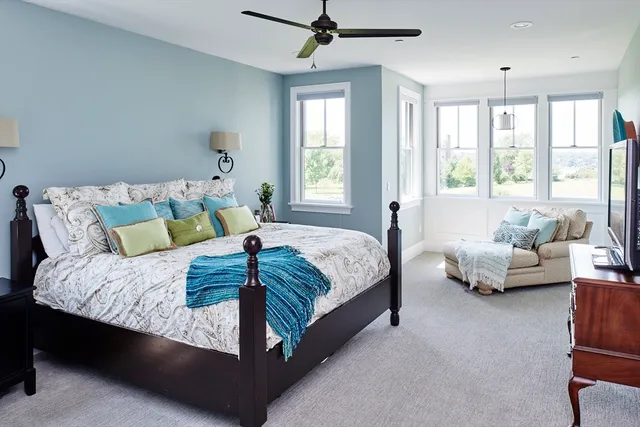 a spacious bedroom with a bed and glass window
