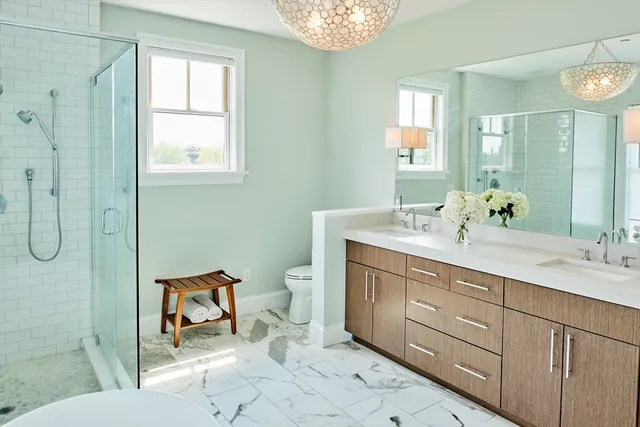 a bathroom with a double vanity sink toilet and shower