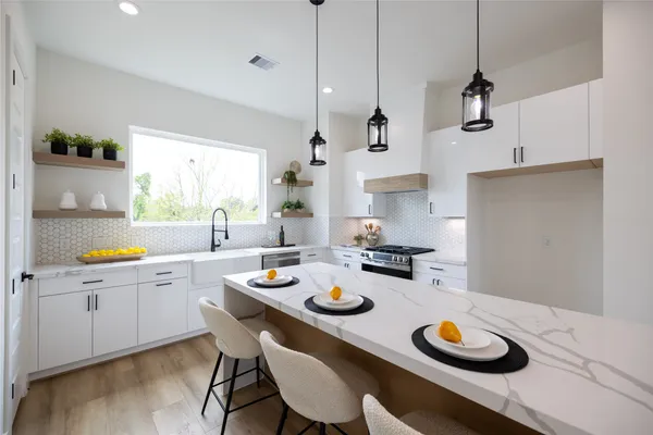 a kitchen with a sink a stove and chairs