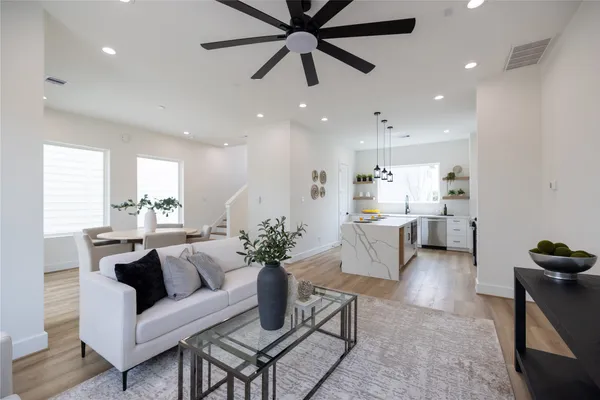 a living room with furniture kitchen view and a potted plant