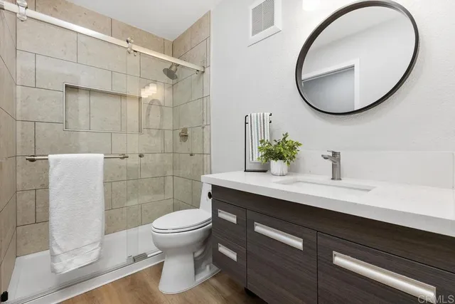 a bathroom with a sink a toilet and a mirror