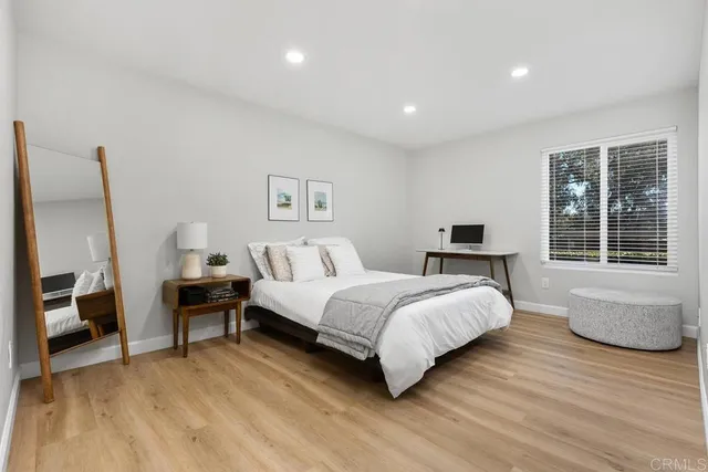 a spacious bedroom with a bed and wooden floor