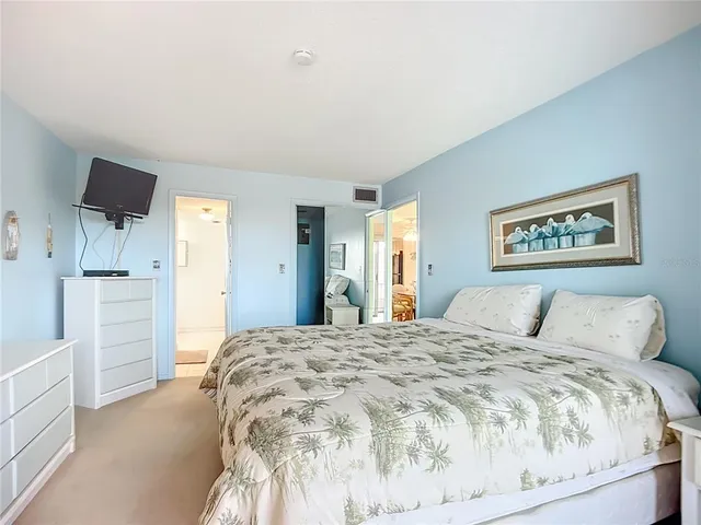 a bedroom with a large bed and a chandelier