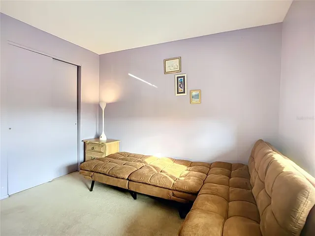 a bedroom with bed couch and painting on the wall