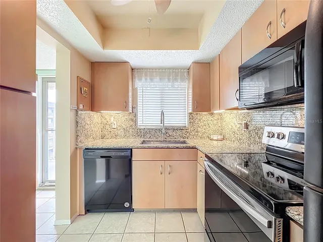 a kitchen with stainless steel appliances granite countertop a sink and a stove