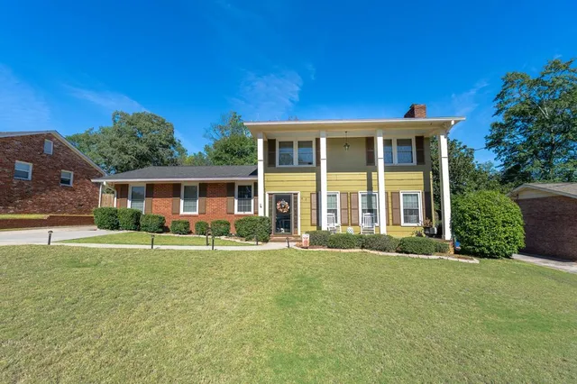 front view of a brick house with a yard
