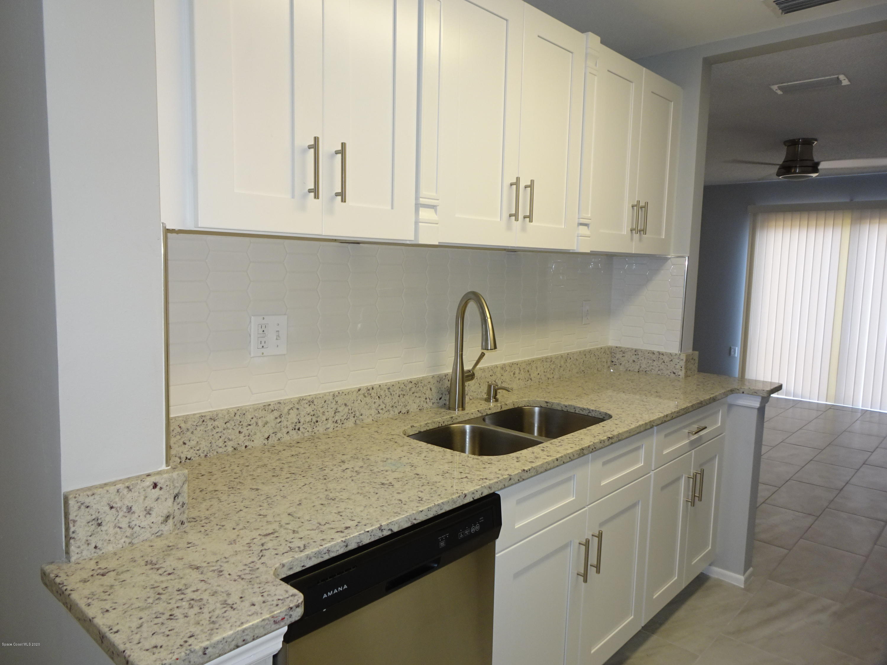 4875 Sisson Road Titusville, FL 32780 - Photo 2 of 14 a kitchen with stainless steel appliances granite countertop a sink and dishwasher with white cabinets