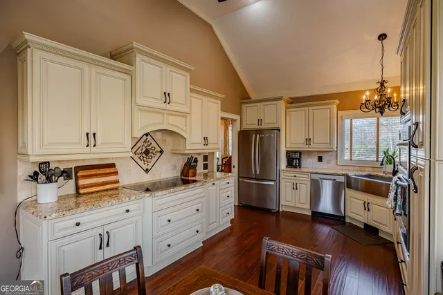 a kitchen with granite countertop a sink stove and refrigerator