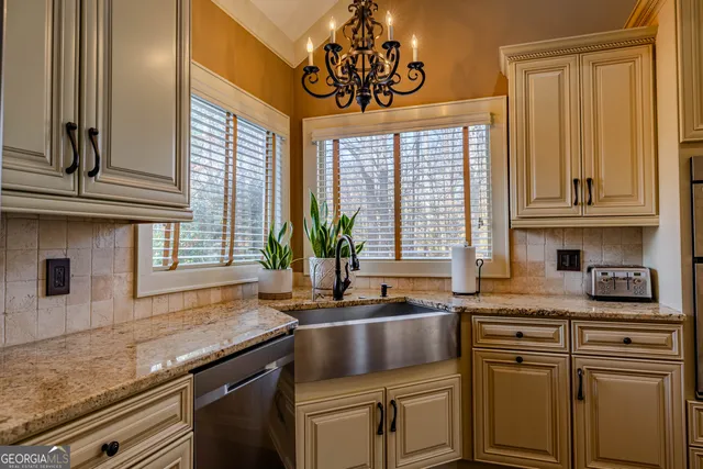 a kitchen with stainless steel appliances granite countertop a sink a stove and cabinets