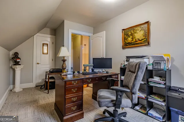 a view of a workspace with furniture and a window