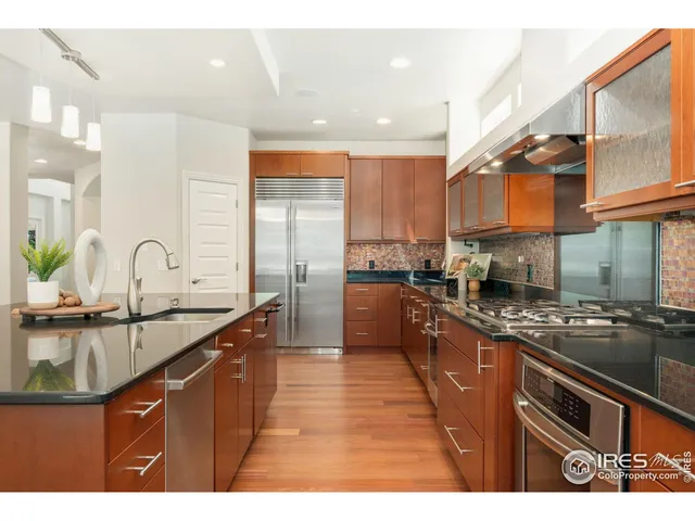 a living room with stainless steel appliances kitchen island granite countertop a table chairs and a couches with kitchen view