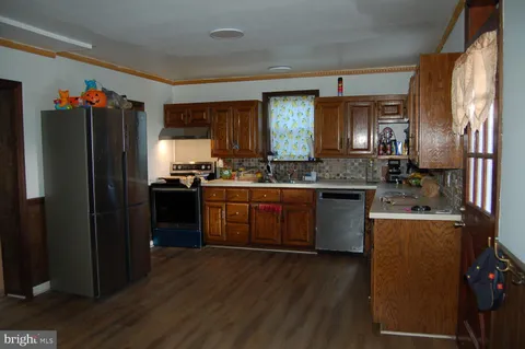 a kitchen with stainless steel appliances granite countertop a refrigerator a sink dishwasher a stove with wooden floor