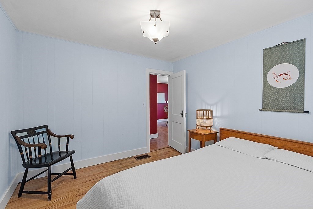 175 Forge Village Road Groton, MA 01450 - Photo 19 of 26 a bedroom with a bed and a chandelier