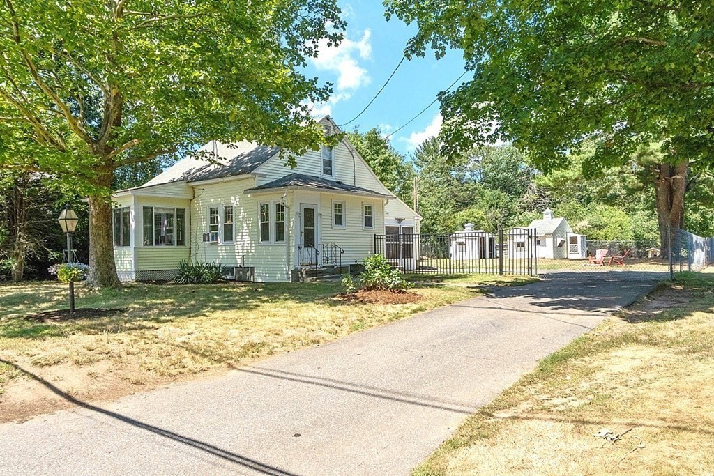 175 Forge Village Road Groton, MA 01450 - Photo 3 of 26 a view of a white house with a large tree and plants