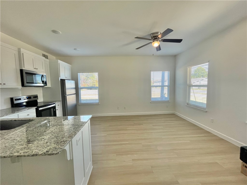 508 Park Street, Unit A Springdale, AR 72764 - Photo 2 of 7 Open-concept living space with light wood-finish flooring, white walls, and a ceiling fan