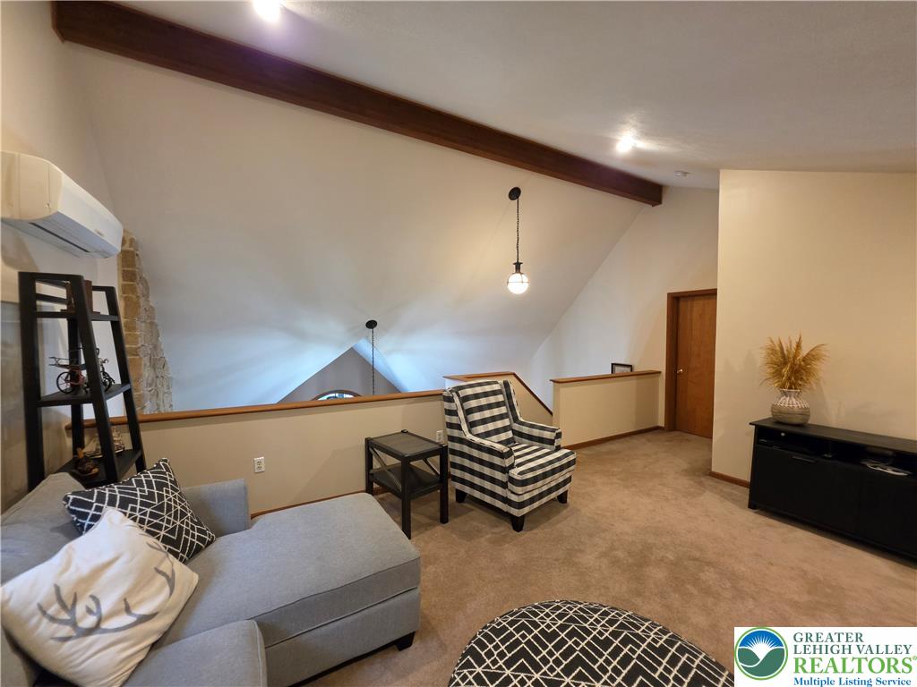 211 Murphy Circle Bushkill, PA 18324 - Photo 15 of 28 An inviting open-concept loft with angled ceilings and a warm, carpeted floor offers versatile living.