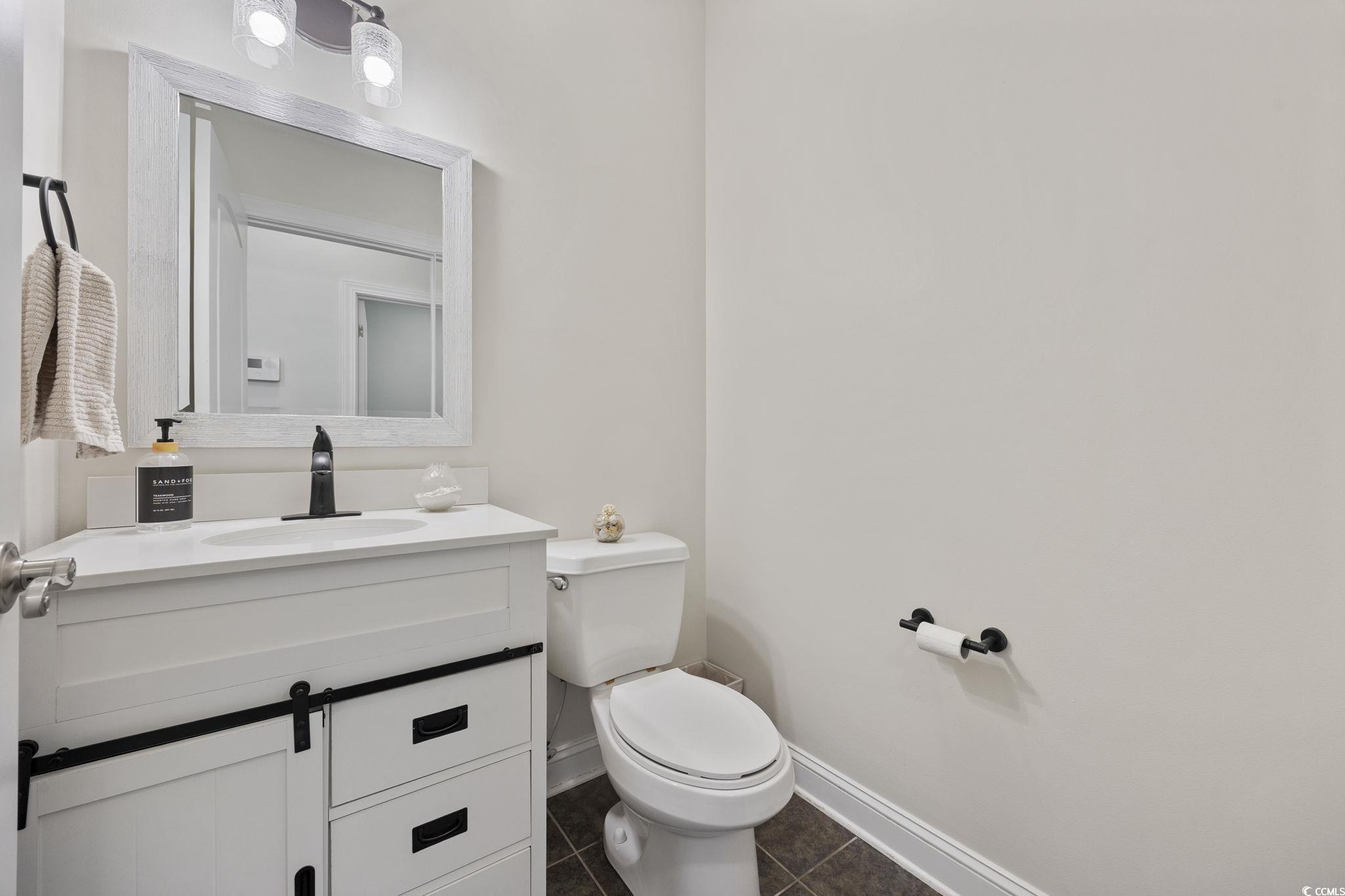 418 Cabo Loop Myrtle Beach, SC 29588 - Photo 18 of 40 Half bathroom featuring vanity and dark tile patterned floors