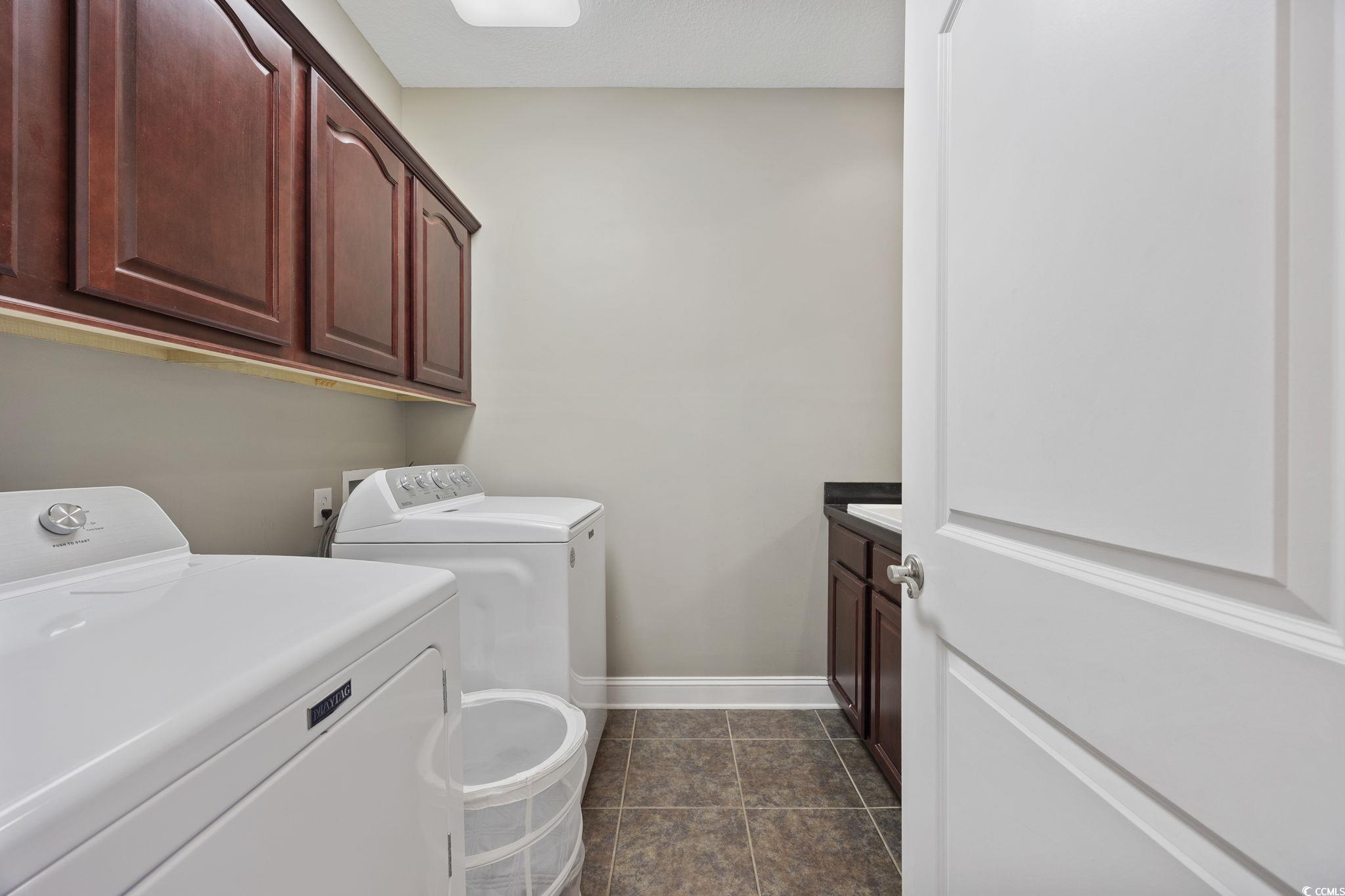 418 Cabo Loop Myrtle Beach, SC 29588 - Photo 19 of 40 Laundry area featuring cabinet space, washer and clothes dryer, and dark tile patterned floors
