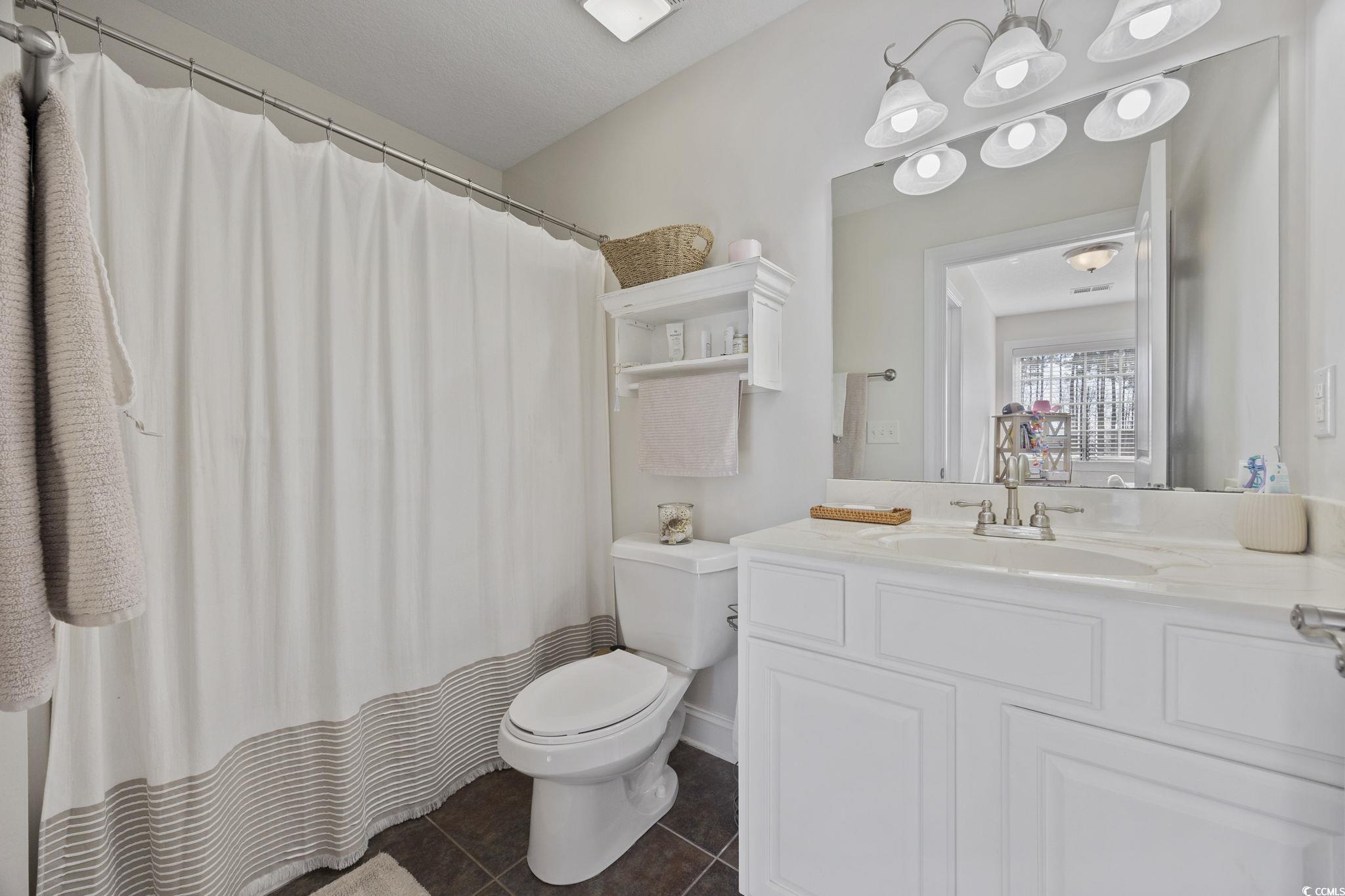 418 Cabo Loop Myrtle Beach, SC 29588 - Photo 26 of 40 Bathroom with a shower with shower curtain, vanity, and dark tile patterned flooring