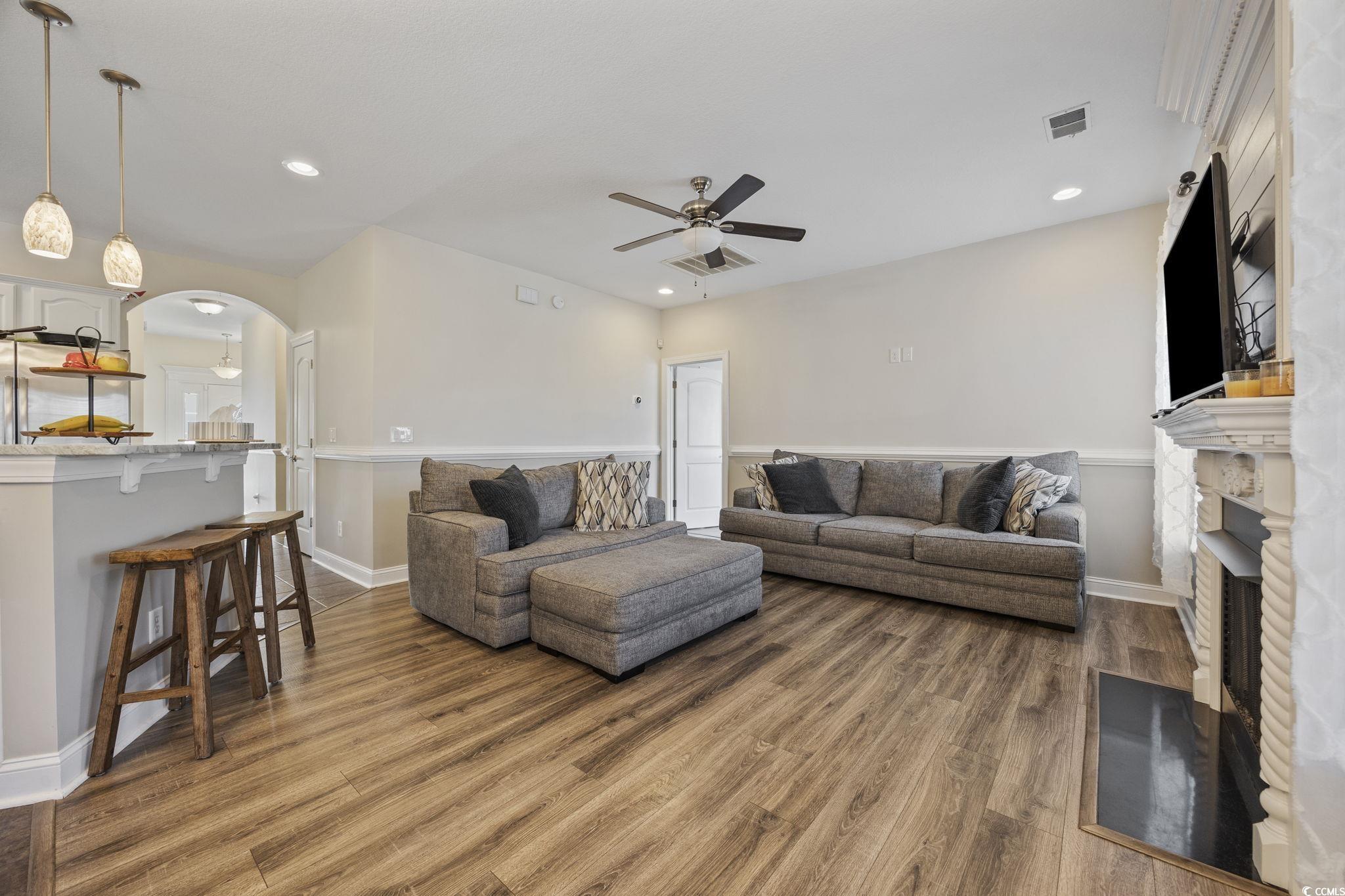 418 Cabo Loop Myrtle Beach, SC 29588 - Photo 6 of 40 Living area with a fireplace with flush hearth, arched walkways, a ceiling fan, wood finished floors, and recessed lighting