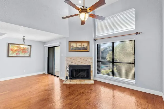 an empty room with windows and fireplace