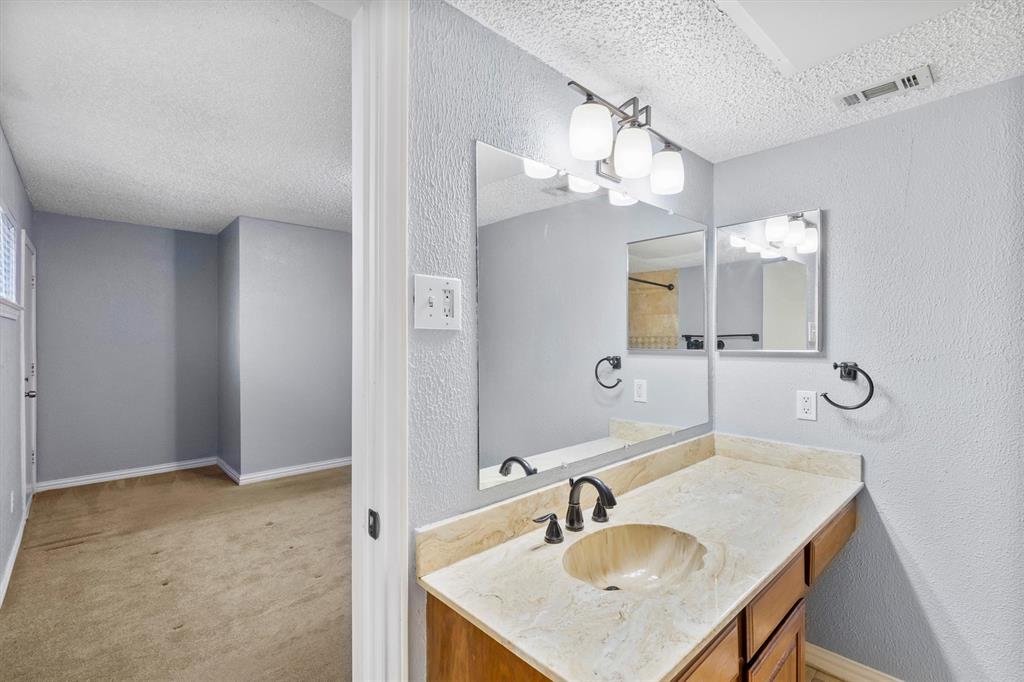5840 Spring Valley Road, Unit 912 Dallas, TX 75254 - Photo 14 of 33 a bathroom with a sink a light fixture and a mirror