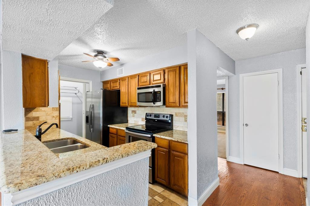 5840 Spring Valley Road, Unit 912 Dallas, TX 75254 - Photo 7 of 33 a view of living room kitchen with granite countertop furniture and fireplace