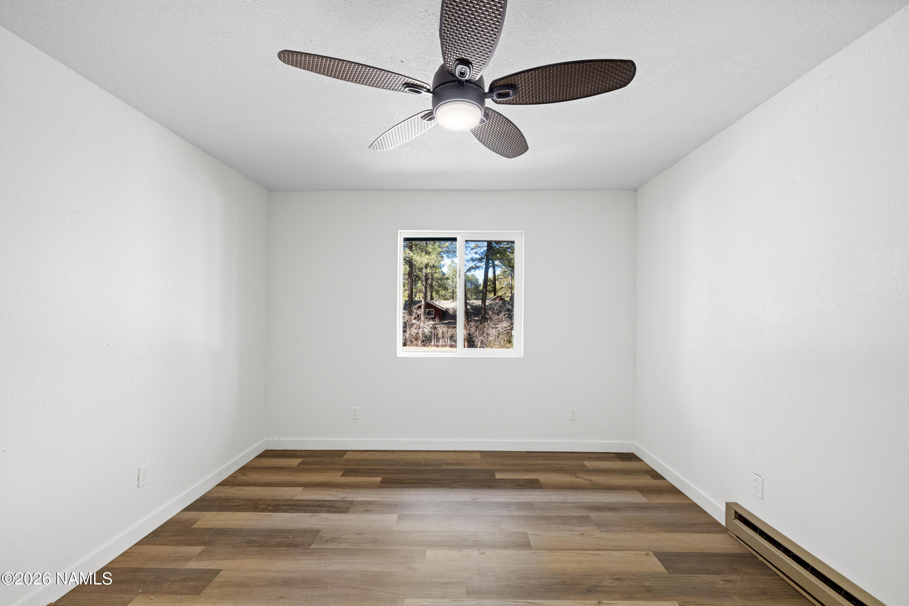 874 Oneida Flagstaff, AZ 86005 - Photo 20 of 30 an empty room with wooden floor ceiling fan and windows