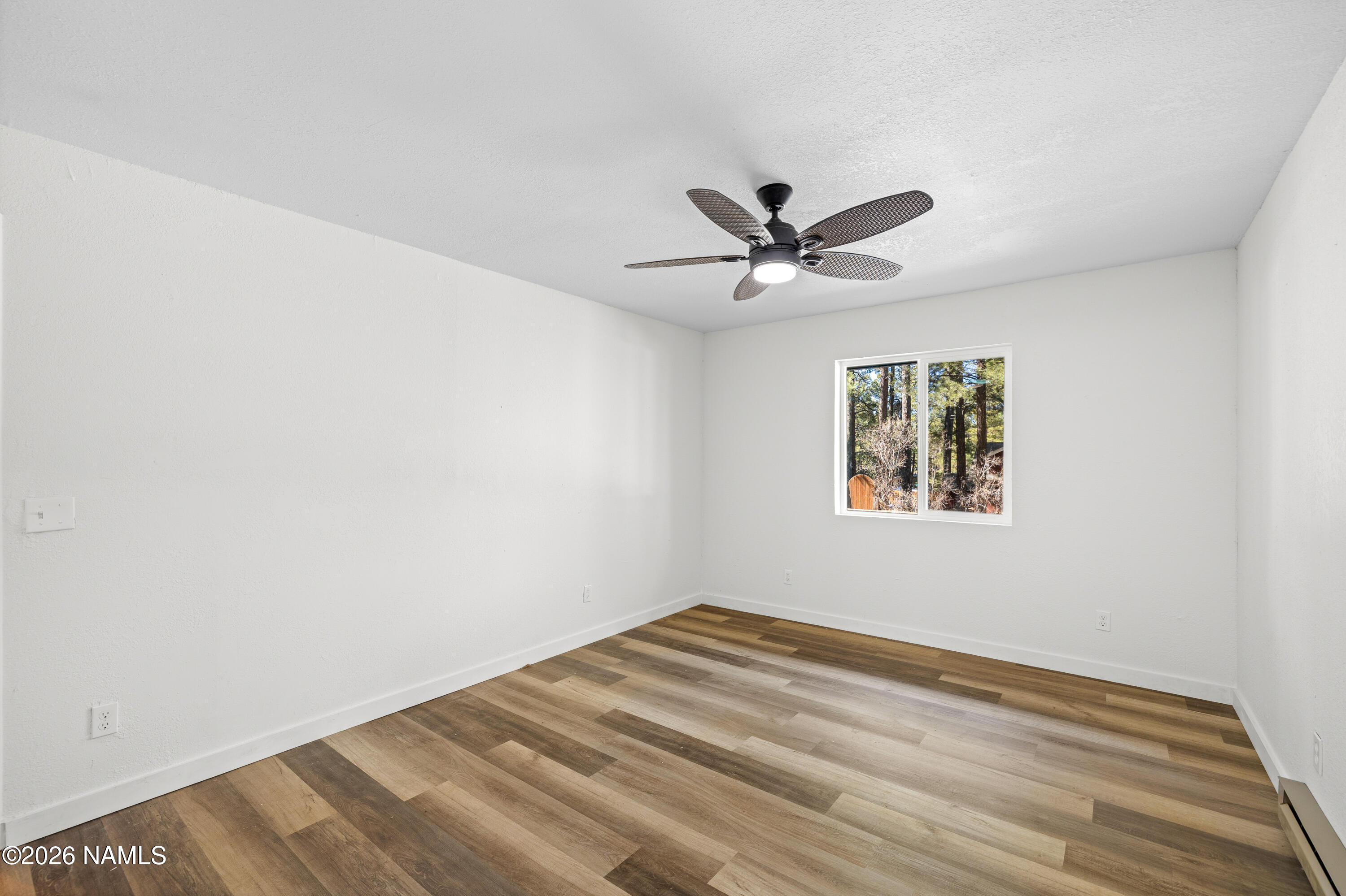 874 Oneida Flagstaff, AZ 86005 - Photo 21 of 30 a view of a big room with wooden floor and a ceiling fan