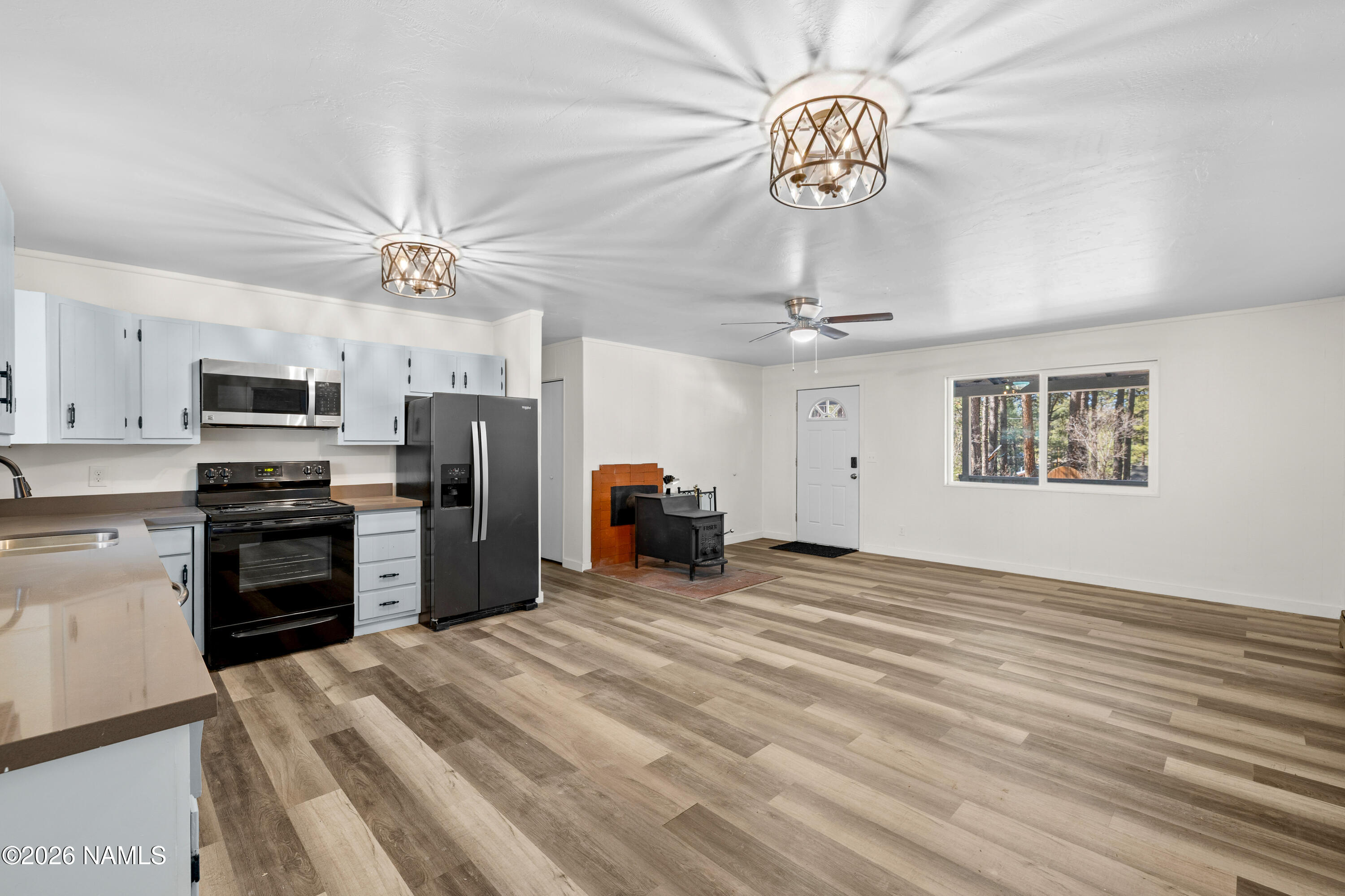 874 Oneida Flagstaff, AZ 86005 - Photo 24 of 30 a view of a kitchen with a stove a kitchen island stainless steel appliances refrigerator cabinets and a chandelier
