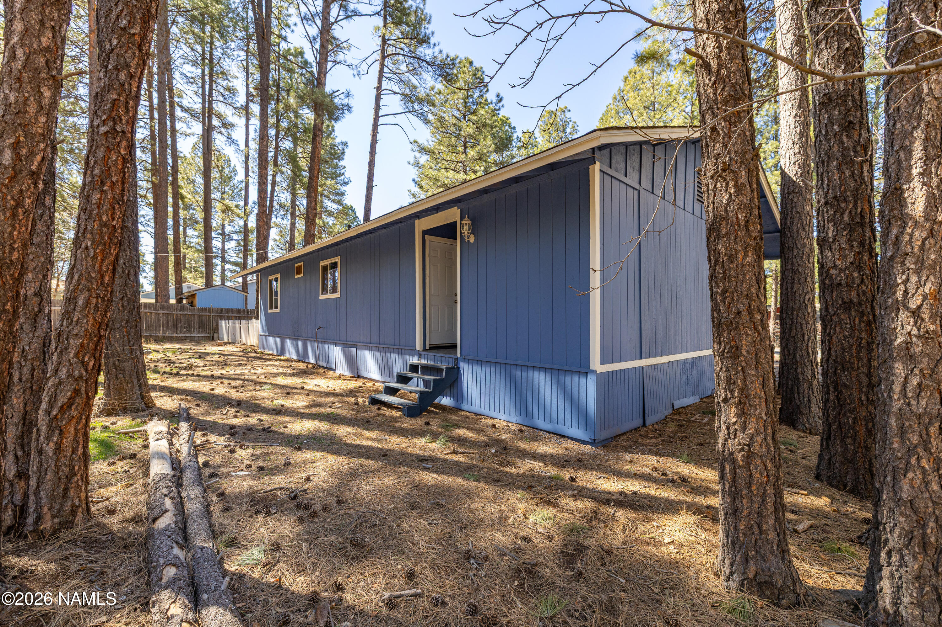 874 Oneida Flagstaff, AZ 86005 - Photo 10 of 30 a view of backyard with large trees and wooden fence