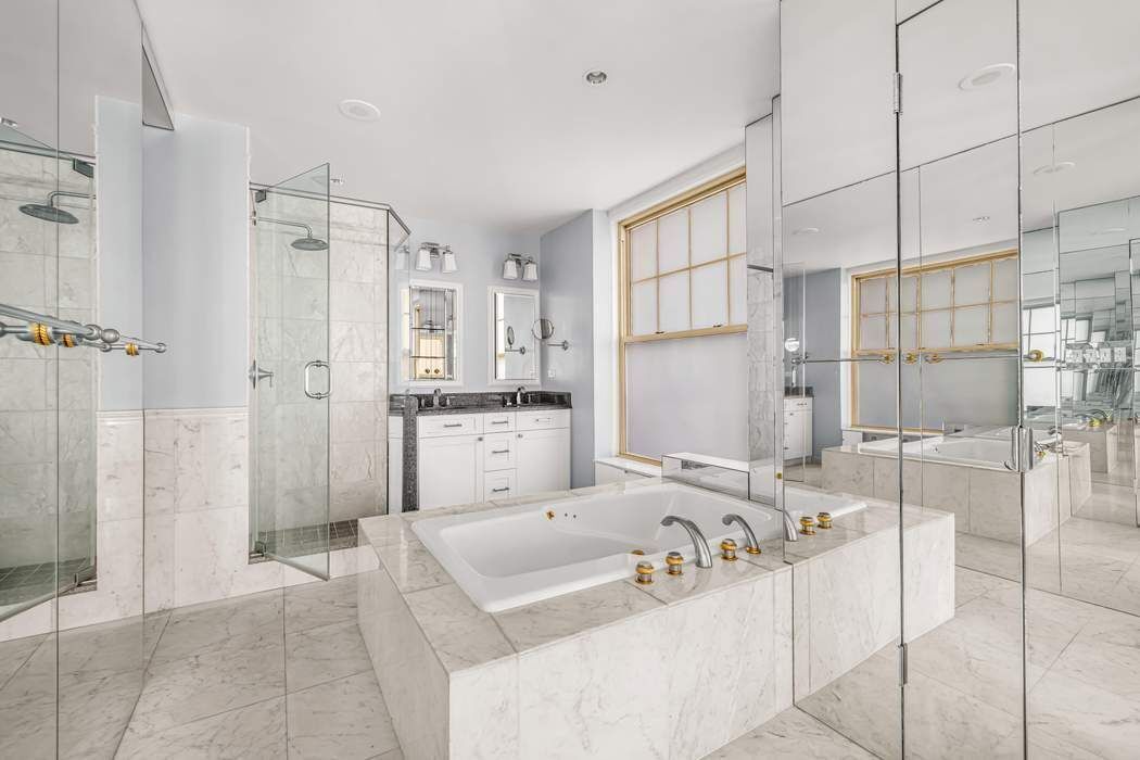 830 Park Avenue, Unit 5/6C Manhattan, NY 10021 - Photo 13 of 19 a bathroom with a tub shower and mirror