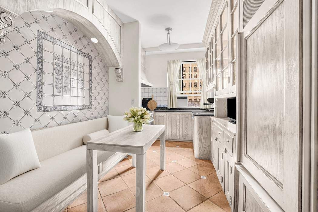 830 Park Avenue, Unit 5/6C Manhattan, NY 10021 - Photo 7 of 19 a kitchen with stainless steel appliances kitchen island granite countertop furniture and a refrigerator
