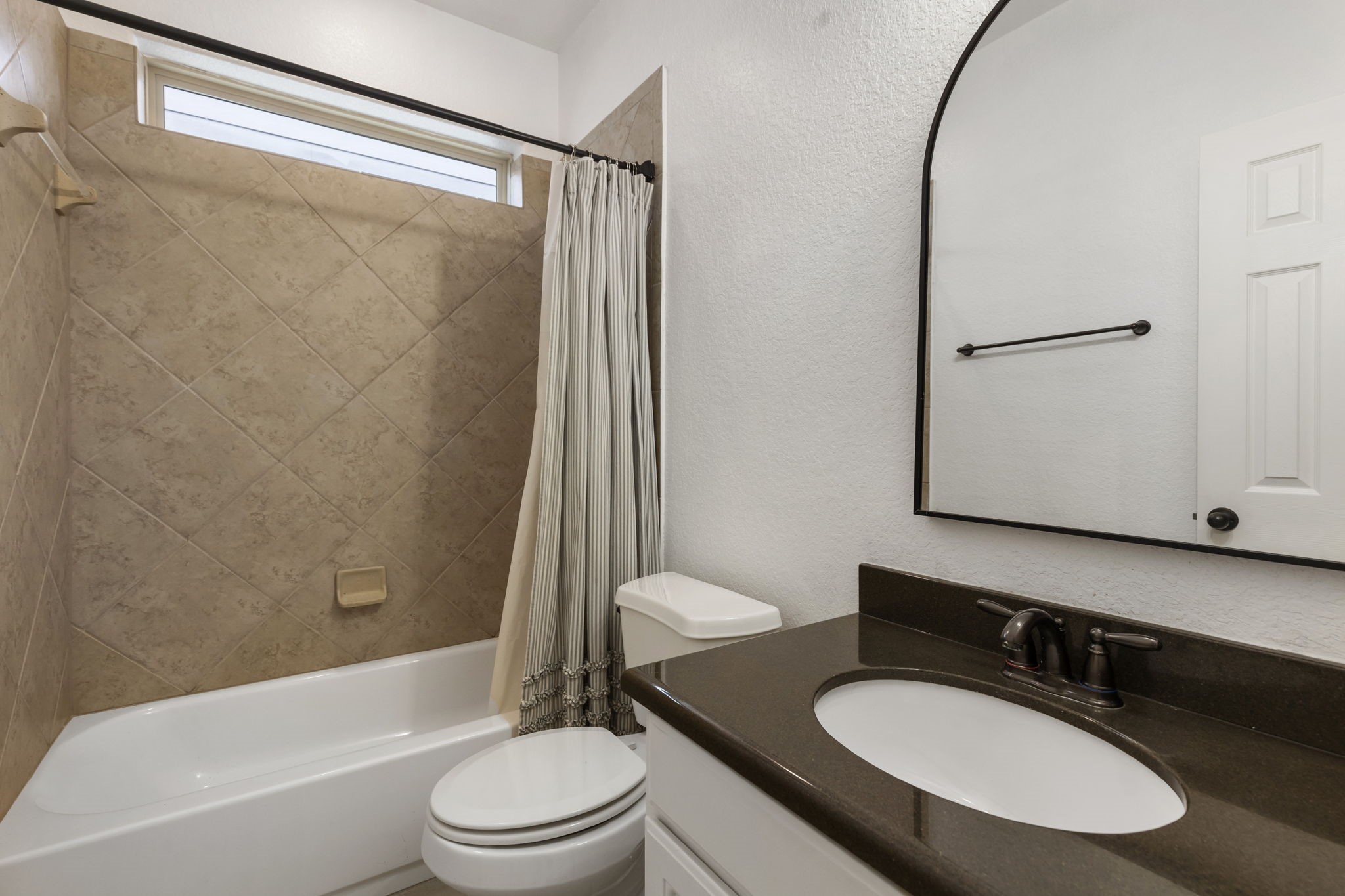 71 Sagamore Ridge Place The Woodlands, TX 77389 - Photo 29 of 34 a bathroom with a granite countertop sink toilet a mirror and shower