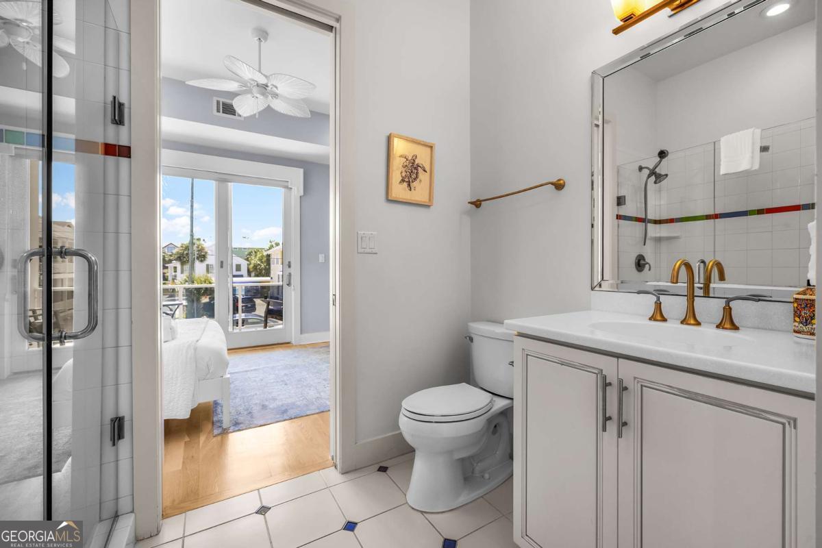 8 18th Street Tybee Island, GA 31328 - Photo 34 of 50 a bathroom with a granite countertop sink a toilet and shower