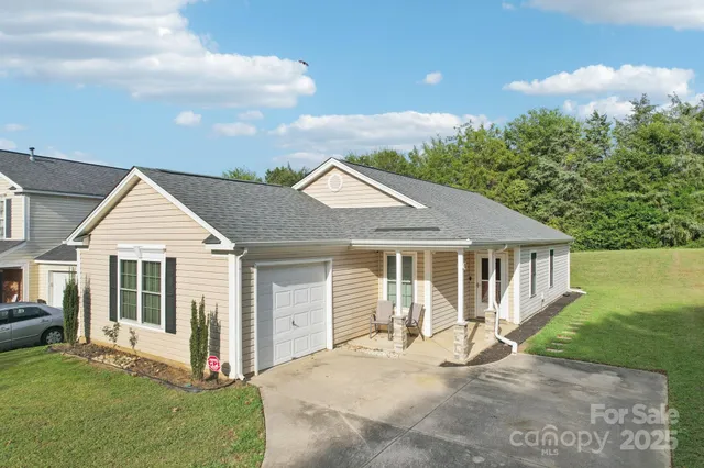 a view of a house with a yard and potted plants