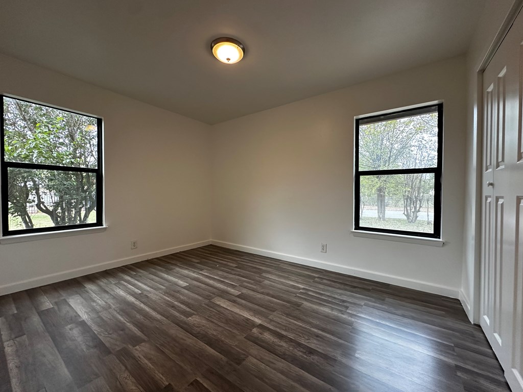 711 Center Street Kerrville, TX 78028 - Photo 5 of 9 a view of an empty room with wooden floor and a window
