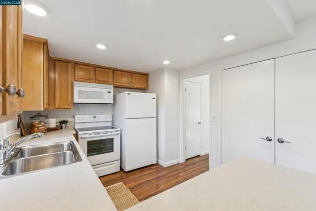 a kitchen with a refrigerator and a stove top oven