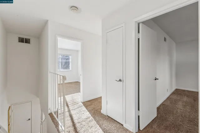 a view of a hallway with bathroom and wooden floor