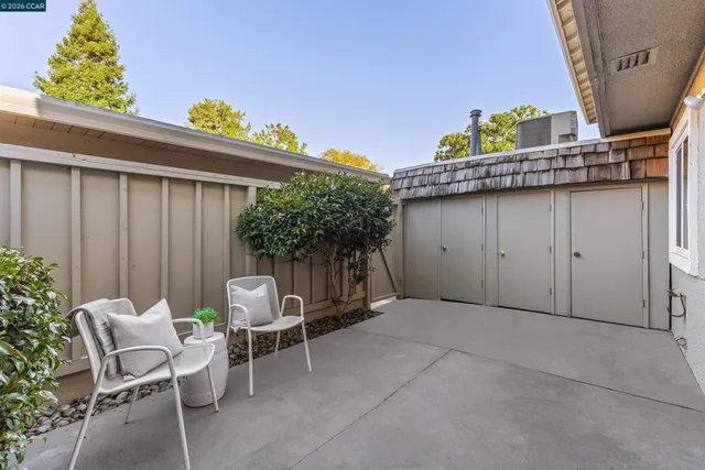 a view of backyard with outdoor seating and plants