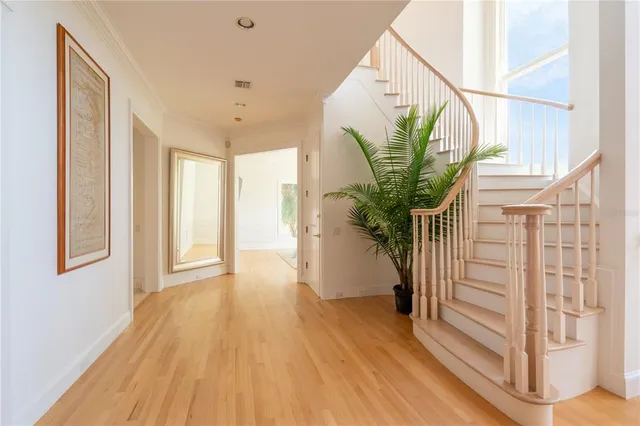 a large bedroom with wooden floor and windows