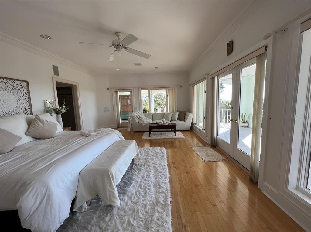 6060 Manasota Key Road Englewood, FL 34223 - Photo 30 of 54 a large bedroom with wooden floor and windows