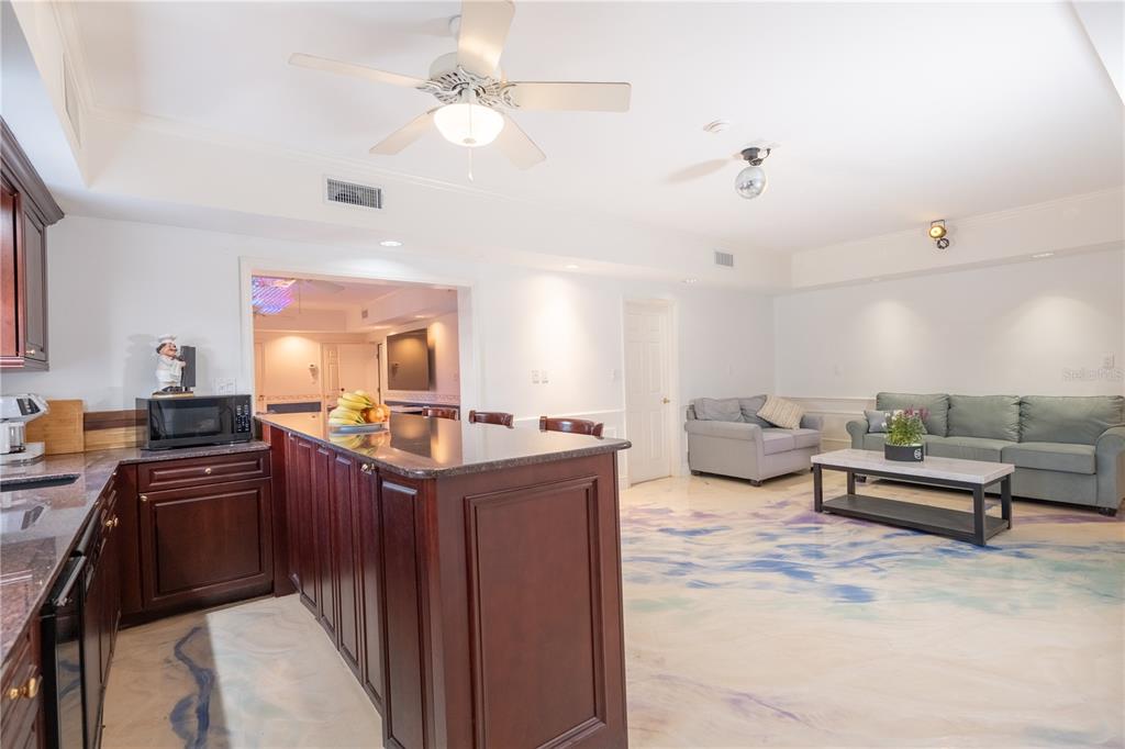 6060 Manasota Key Road Englewood, FL 34223 - Photo 46 of 54 a kitchen with stainless steel appliances kitchen island granite countertop a sink dishwasher a dining table and chairs with wooden floor