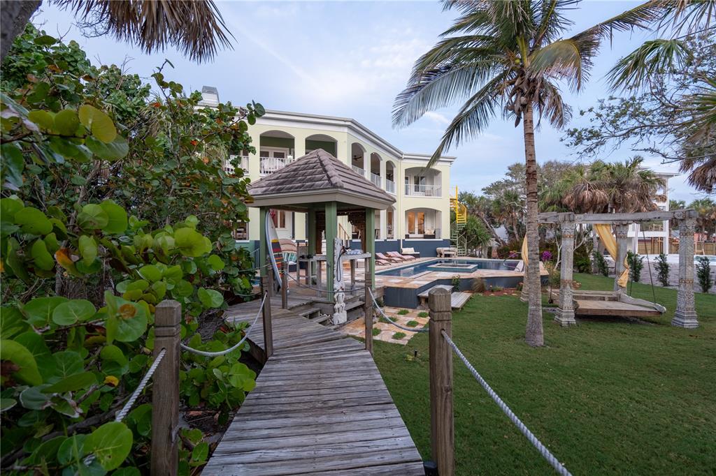 6060 Manasota Key Road Englewood, FL 34223 - Photo 49 of 54 a front view of a house with a garden and sitting area
