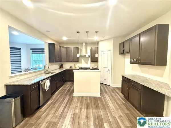 a large kitchen with stainless steel appliances kitchen island granite countertop wooden cabinets and a granite counter tops