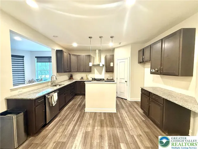 a large kitchen with stainless steel appliances kitchen island granite countertop wooden cabinets and a granite counter tops