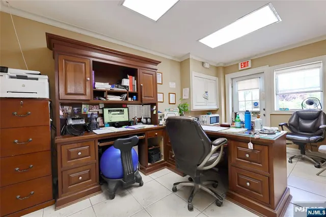 a view of a workspace with furniture and a window